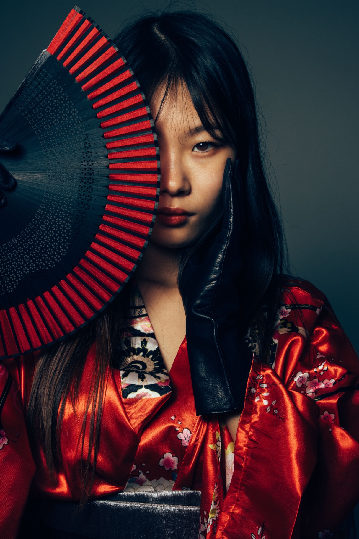 Model in a red silk kimono holding a red and black folding fan