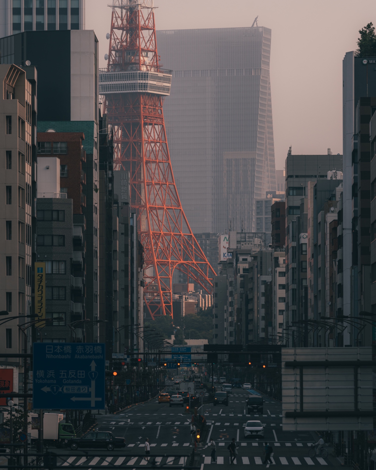 Tokyo Tower framed by city buildings at dawn