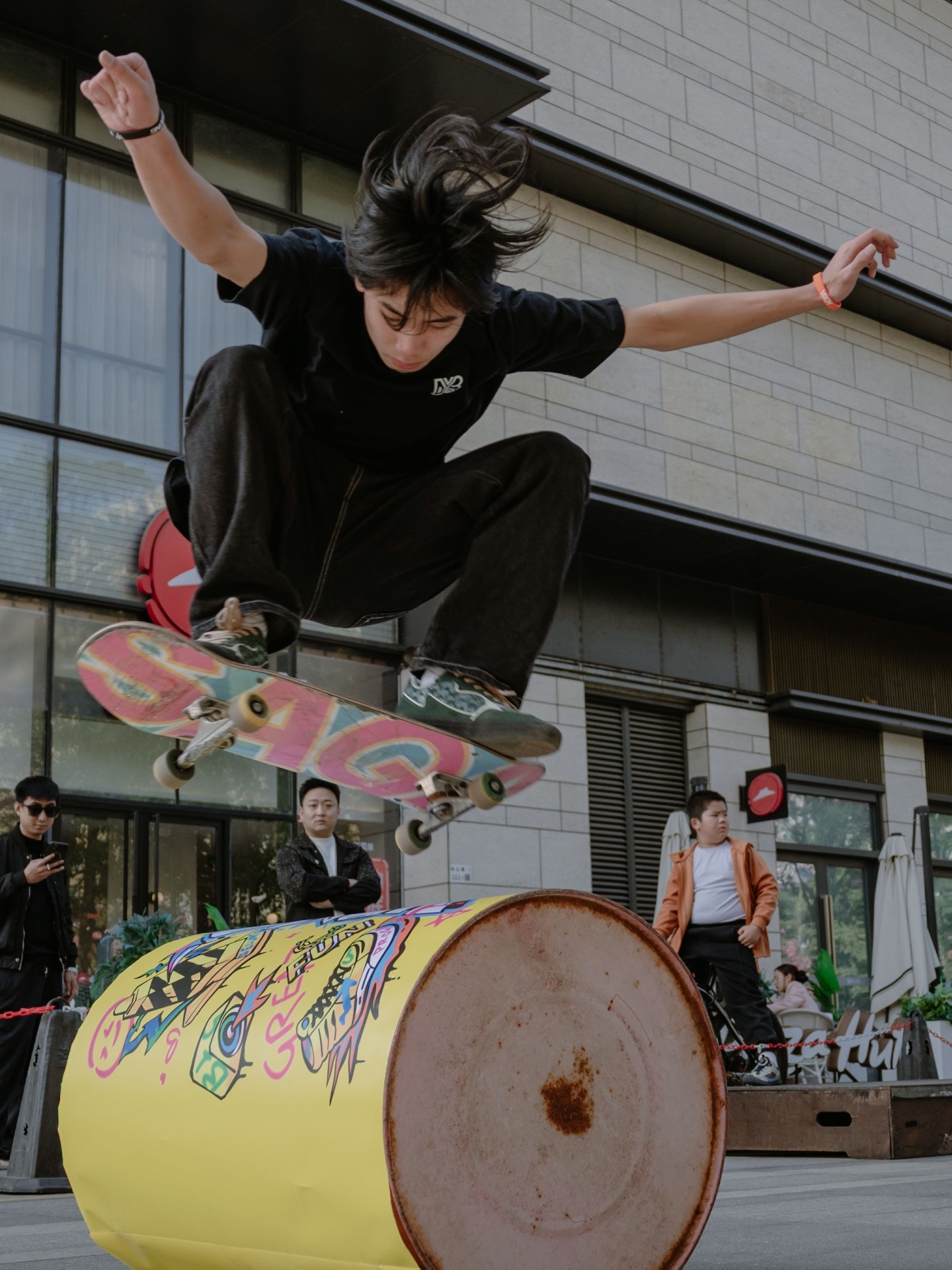 Street skater airborne over a painted barrel